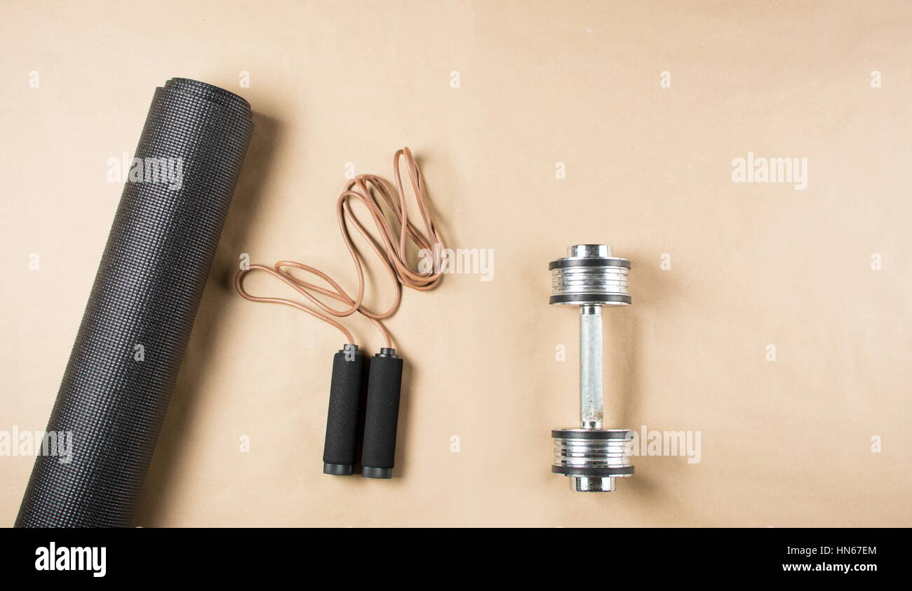 Yoga mat with dumbbell and leather jumping rope Stock Photo Alamy