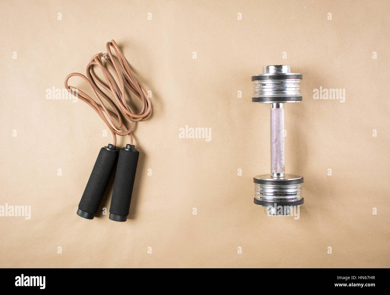 Leather jumping rope and a dumbbell. Workout time Stock Photo Alamy