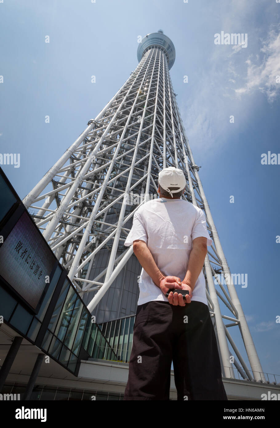 TOKYO - MAY 26: A man looks up at the Tokyo Skytree in Japan's capital city. The Skytree opened to the public on 22 May 2012, it is the tallest tower  Stock Photo