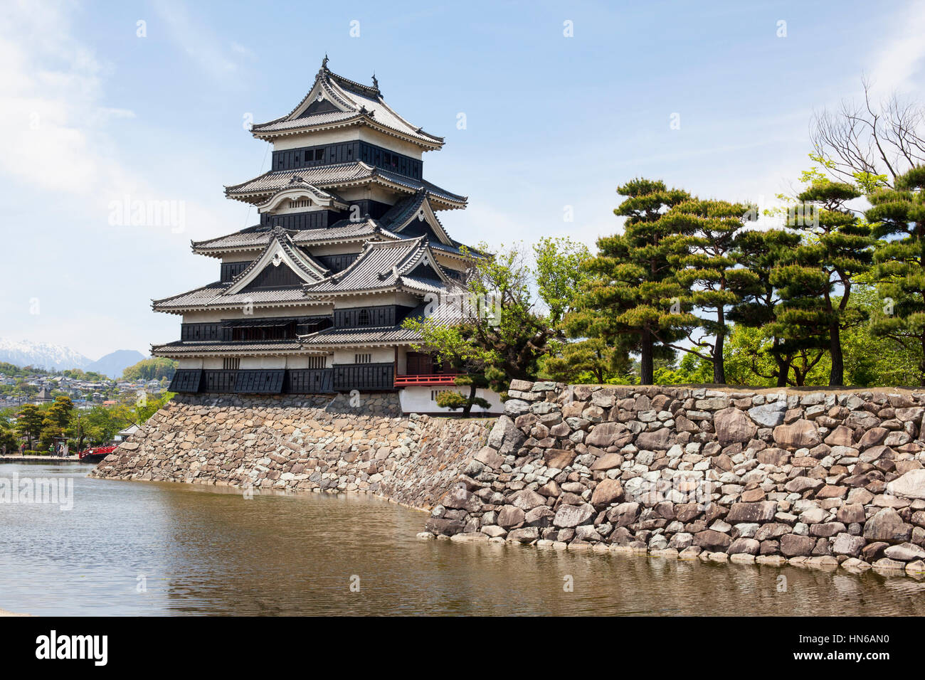Matsumoto, Japan - May 13, 2012: The black and white wooden keep of Matsumoto castle with stone block foundations and walls surrounded by a moat. The  Stock Photo