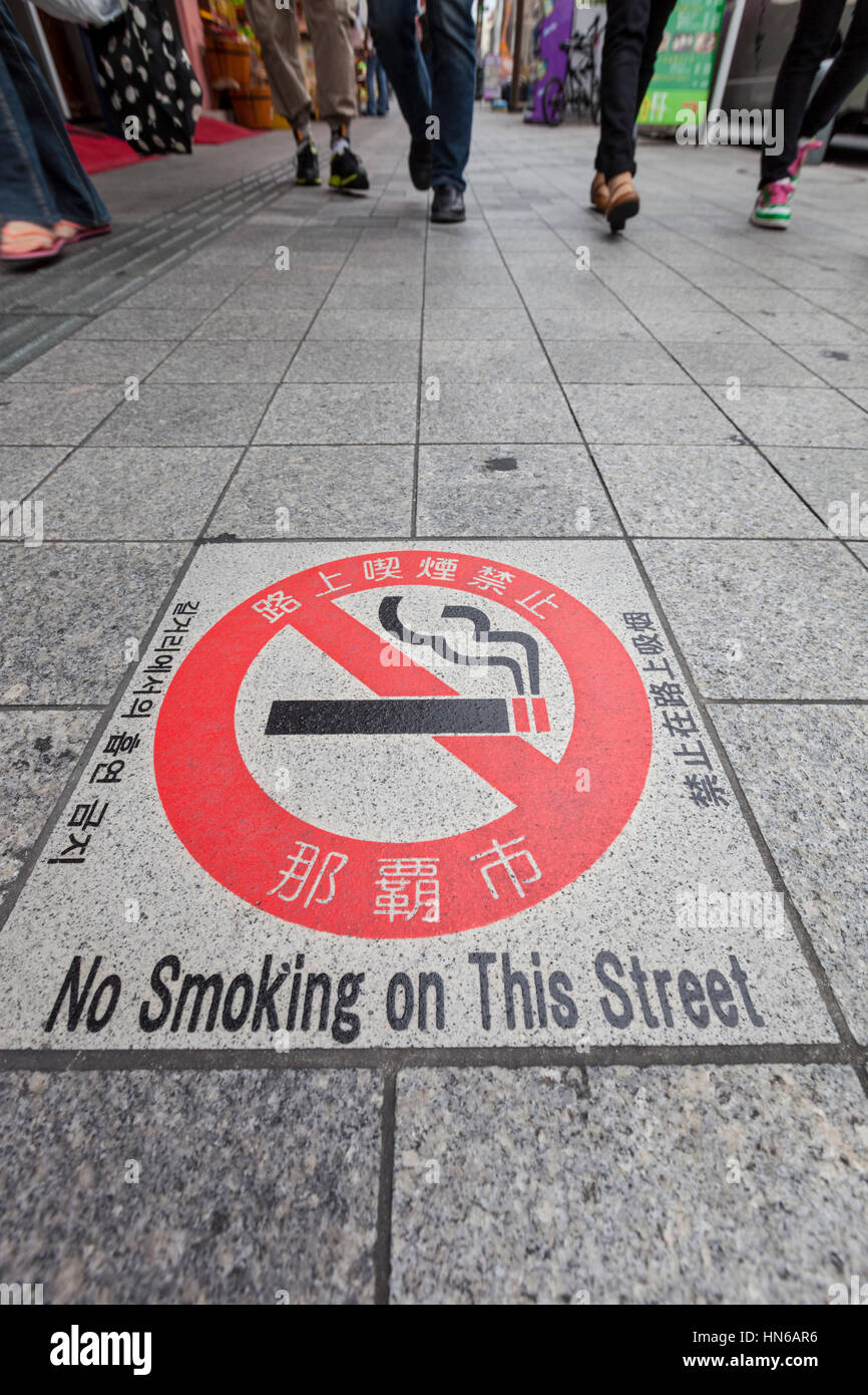Naha, Japan - April 2, 2012: A no smoking warning sign built into the pavement of Kokusaidori, a busy tourist street in the city of Naha in Okinawa pr Stock Photo