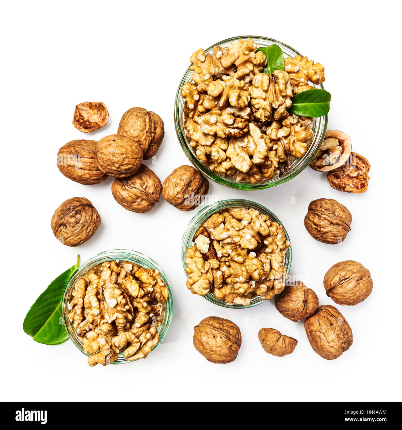 Walnut kernels in glass bowl, whole walnuts and nutshells as healthy eating and dieting concept, group of objects isolated on white background Stock Photo