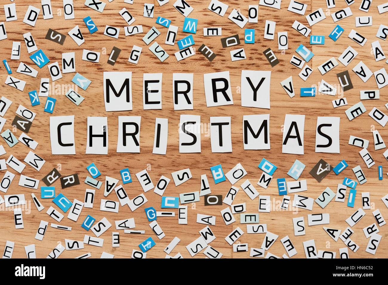 merry cristmas words cut out from magazine on wood Stock Photo