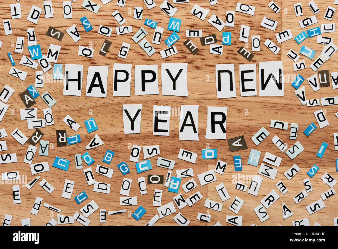 happy new year word cut out from magazine on wood Stock Photo