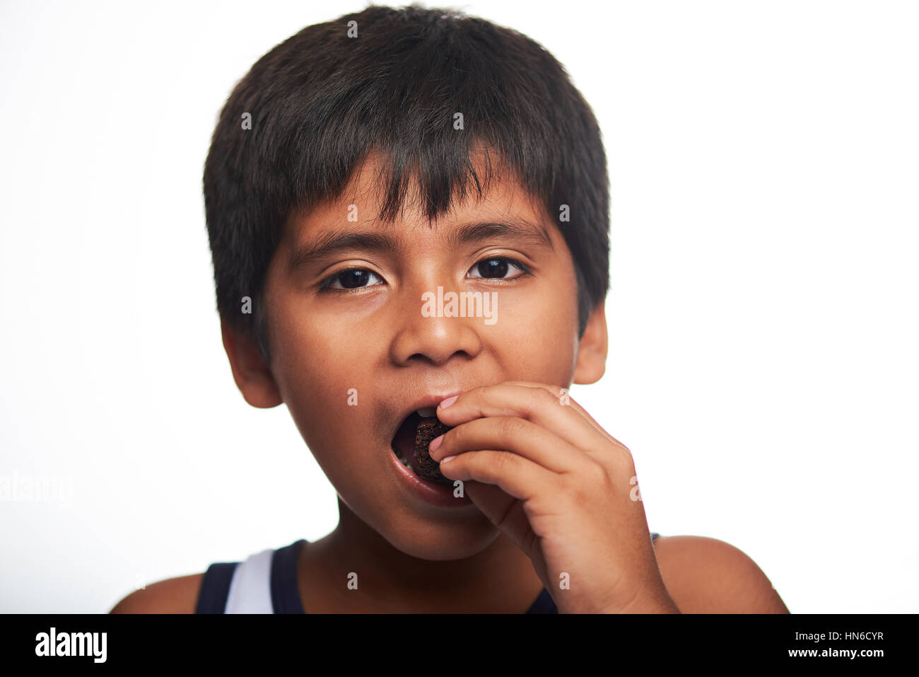 latino boy eat chocolate cake isolated on white background Stock Photo