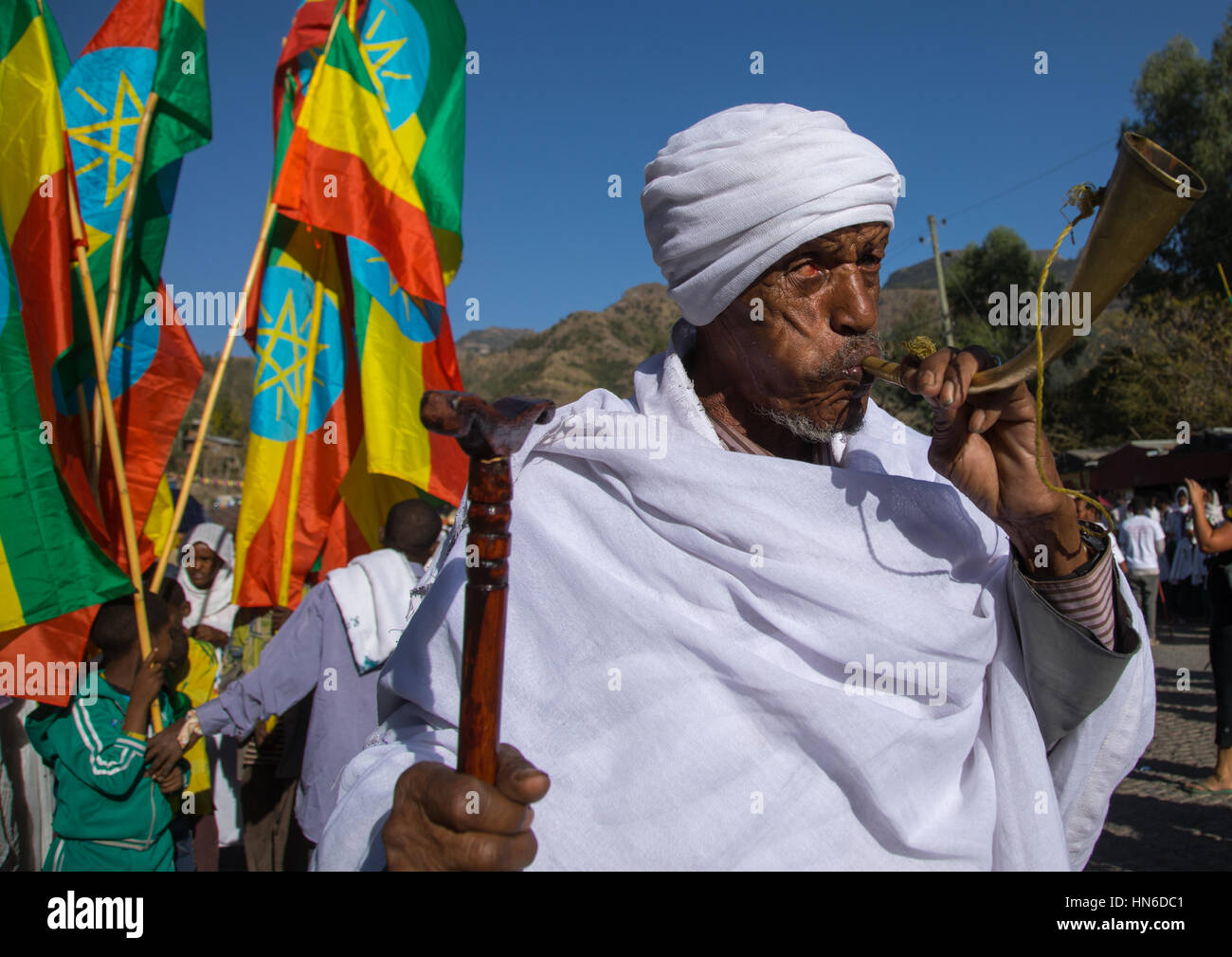 Ethiopian orthodox priest blowing in a horn during the colorful Timkat epiphany festival, Amhara region, Lalibela, Ethiopia Stock Photo