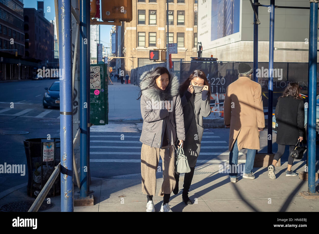 Intrepid Asian tourists in the trendy gallery district in West Chelsea battle the cold and windy weather on Saturday, February 4, 2017. (© Richard B. Levine) Stock Photo
