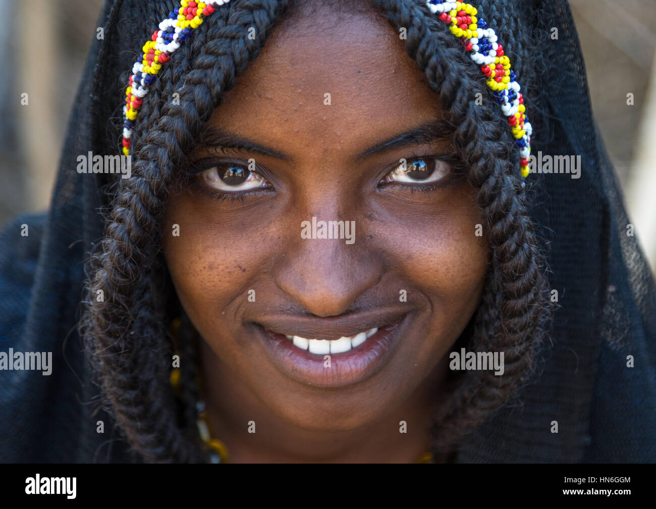 Portrait of a smiling Afar tribe girl with braided hair ands beaded headband, Afar region, Chifra, Ethiopia Stock Photo