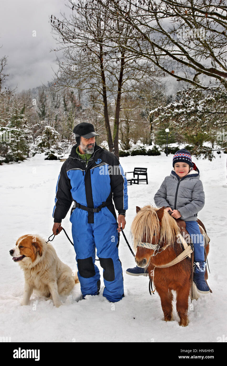 Little boy riding a pony at Ninemia Bungalows Resort, in Potamia Valley, between Voutyro and Klafsi villages, Evrytania, Central Greece. Stock Photo