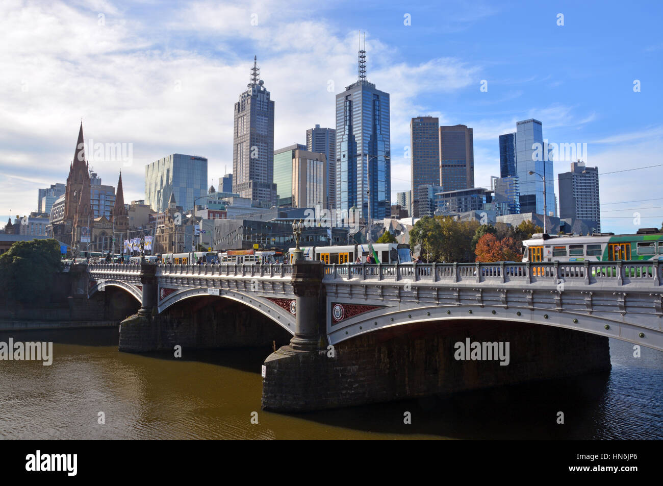 Melbourne, Australia - May 14, 2014: Melbourne city viewed from the South Bank of the Yarra River. In the foreground trams cross the St Kilda Road bri Stock Photo