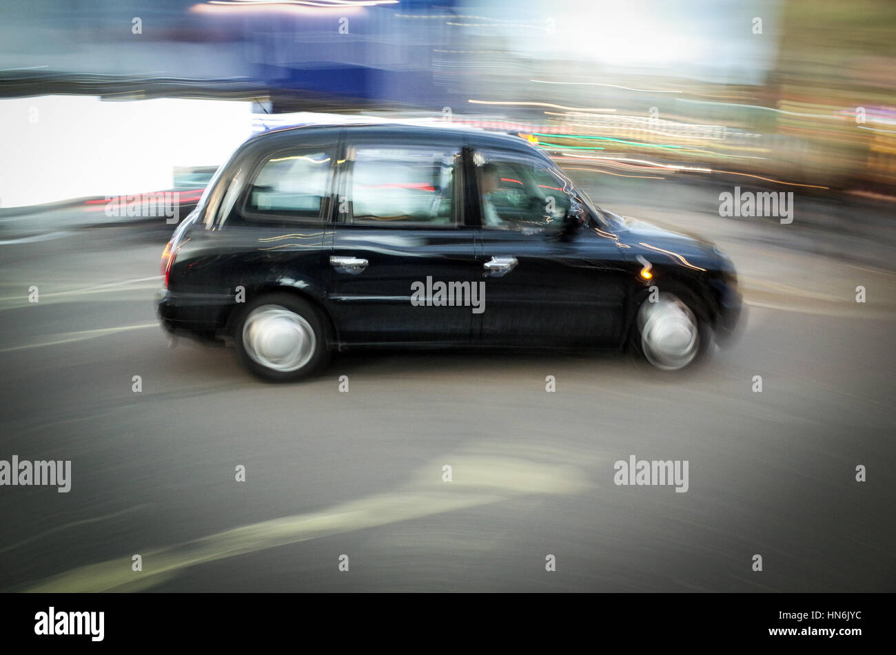 A London Taxi drives through Piccadilly Circus - Motion Blur Stock Photo