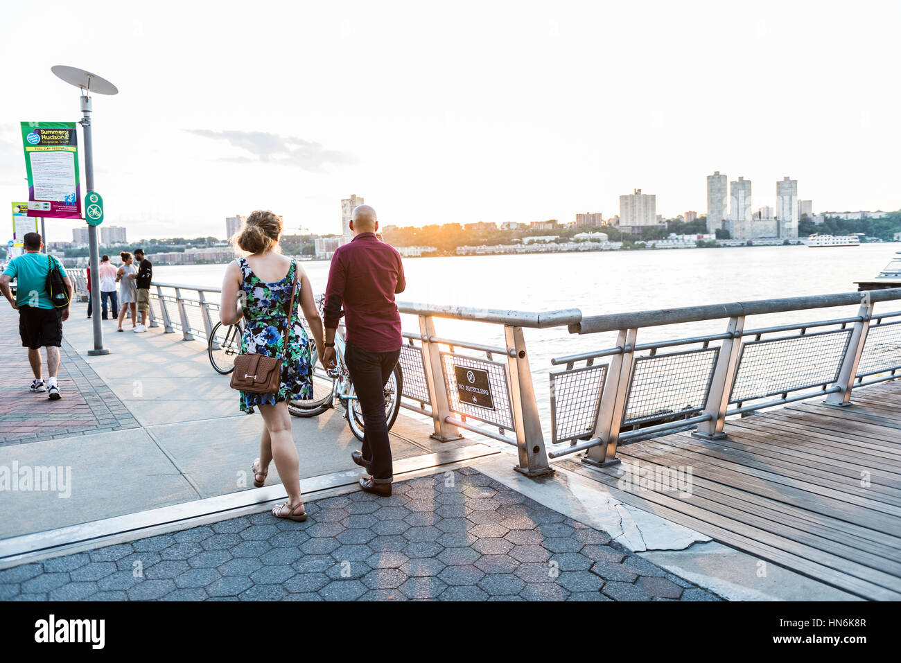 New York, USA - June 18, 2016: A couple walking down the boardwalk of riverside park pier 1 in New York City with view of New Jersey Stock Photo