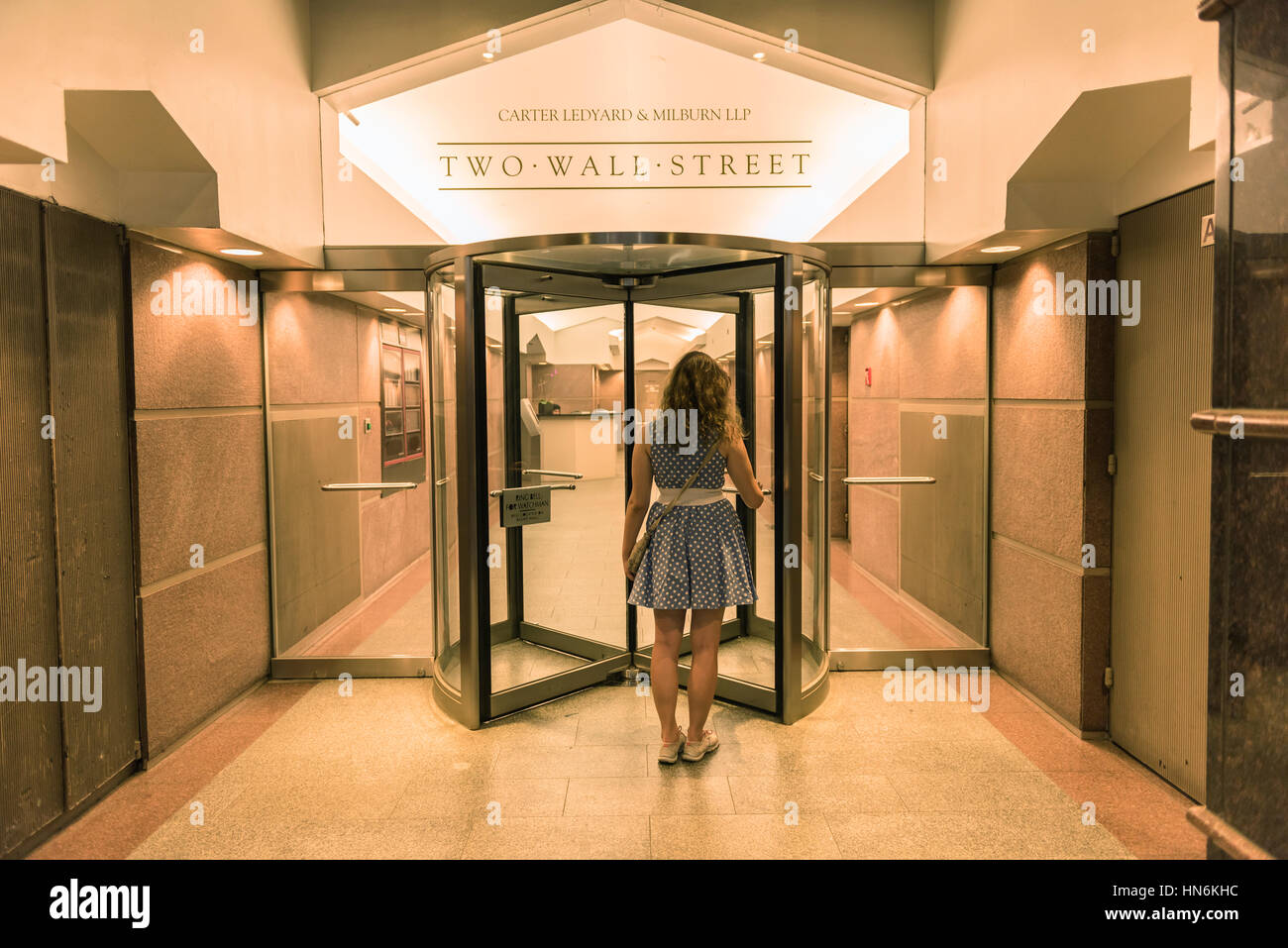 New York, USA - June 18, 2016: Woman entering Two Wall Street with the office of Carter Ledyard and Milburn LLP Stock Photo