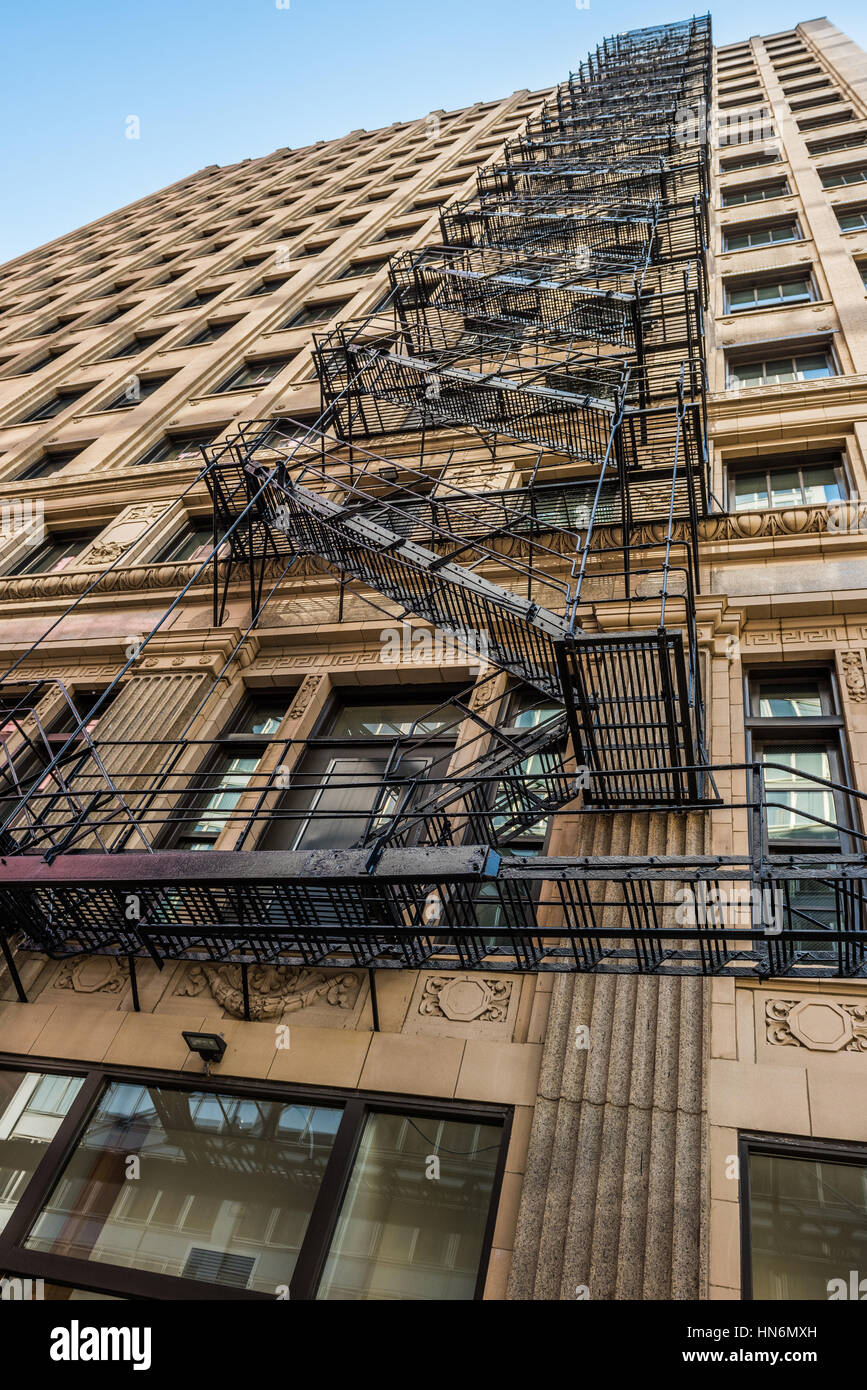 Old and rusty fire escape ladders and staircase in downtown Chicago on skyscraper Stock Photo