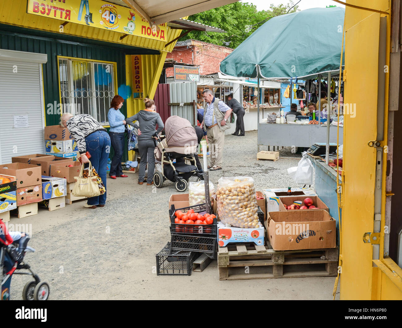 Rivne, Ukraine - May 14, 2013: People at local farmers market or bazaar selling and buying fruits and vegetables Stock Photo