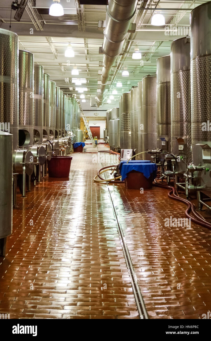 Modern winery factory with large metal aluminum fermentation tanks or