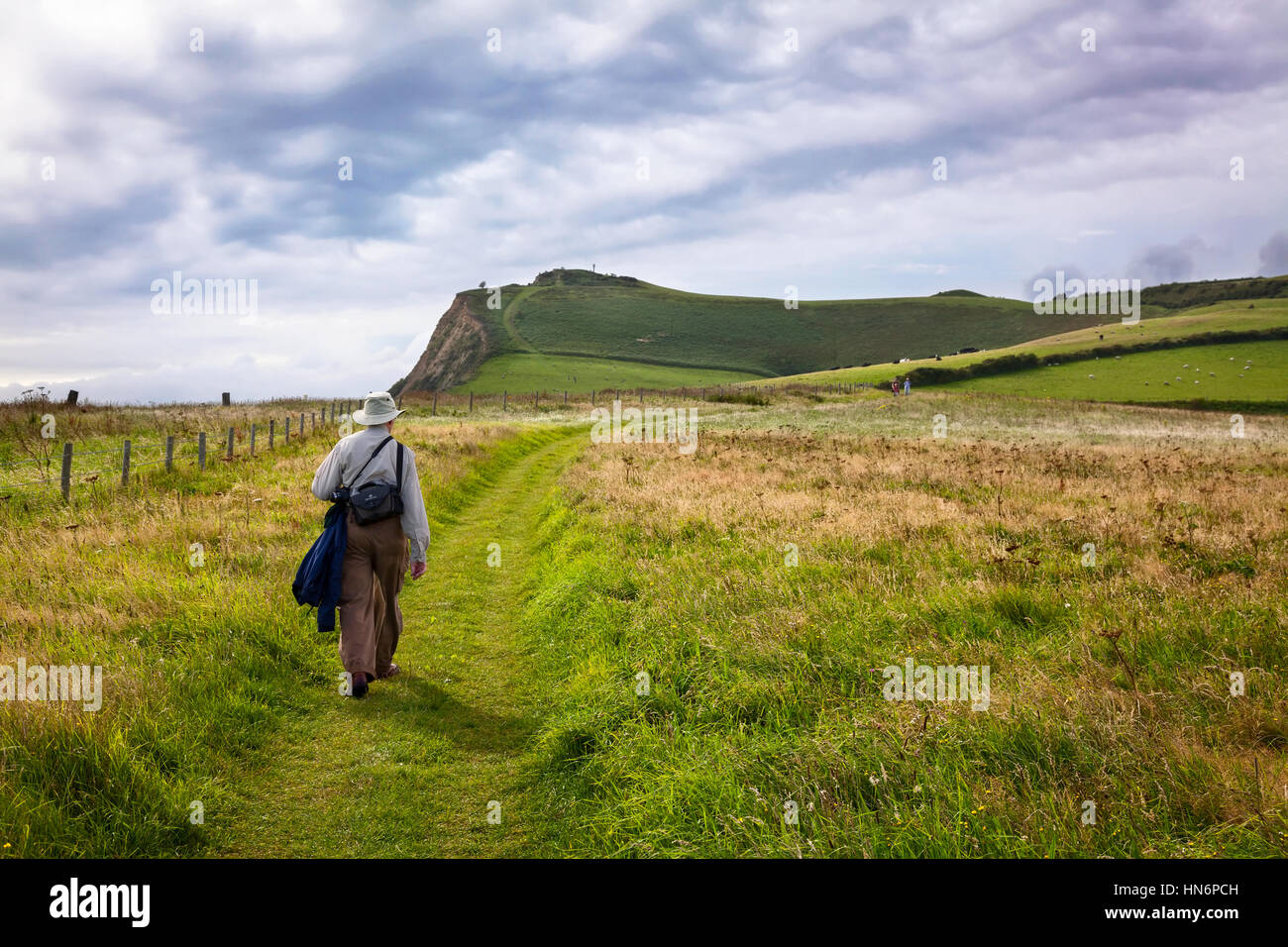 A man walking along the South West Coast Path in Dorset, England. Stock Photo