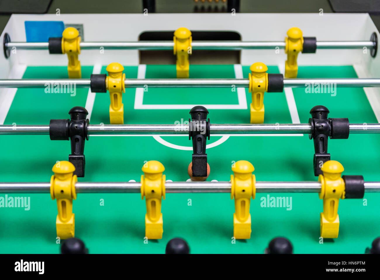 Closeup of foosball table with figures and ball rolling Stock Photo