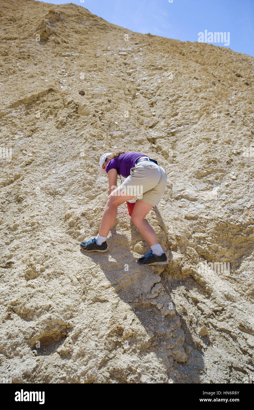 Young woman rock climbing sandstone canyon in Death Valley, California