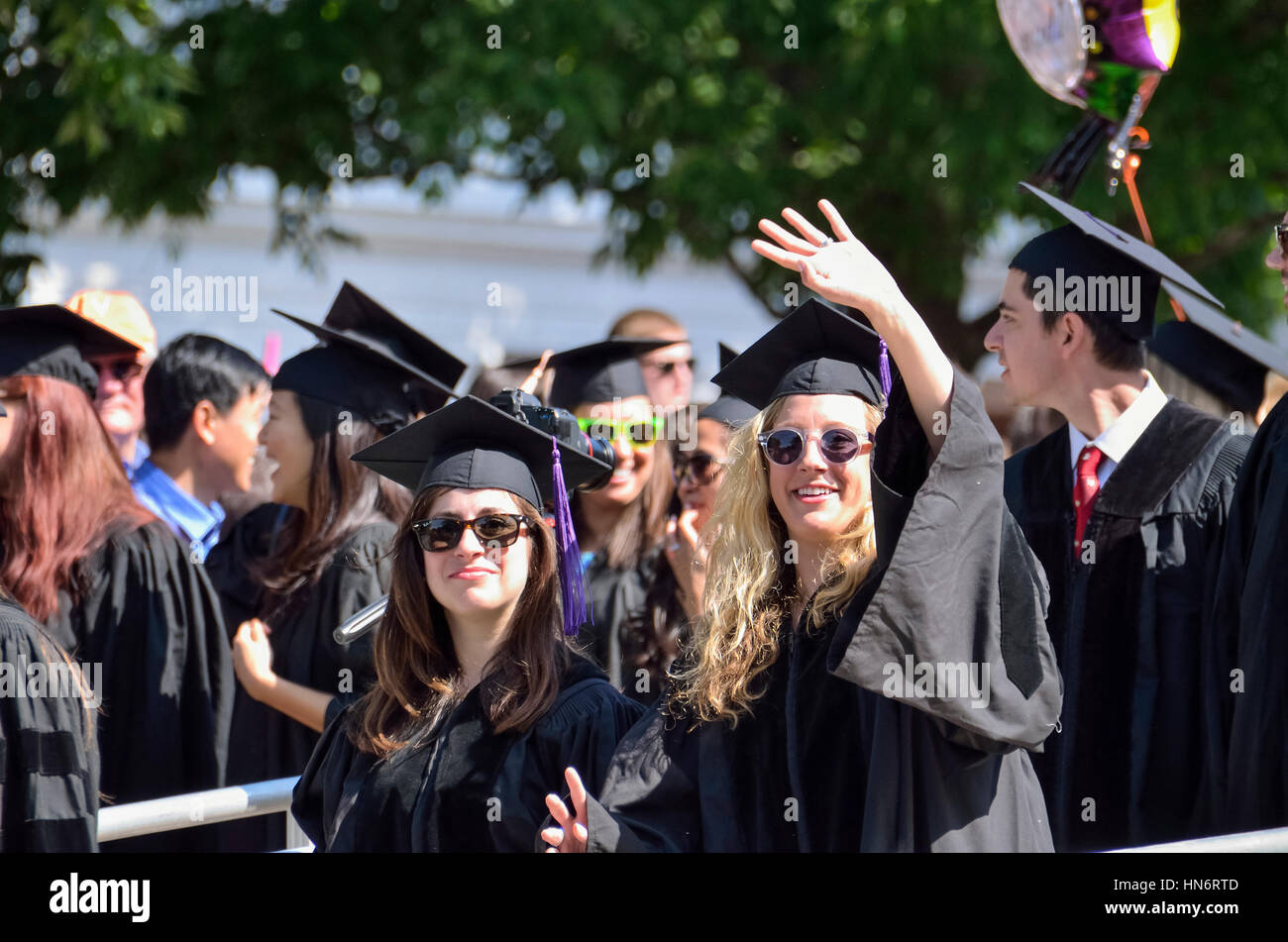 Charlottesville, USA - May 18, 2014: Girls waving at graduation ceremony in gowns at University of Virginia Stock Photo