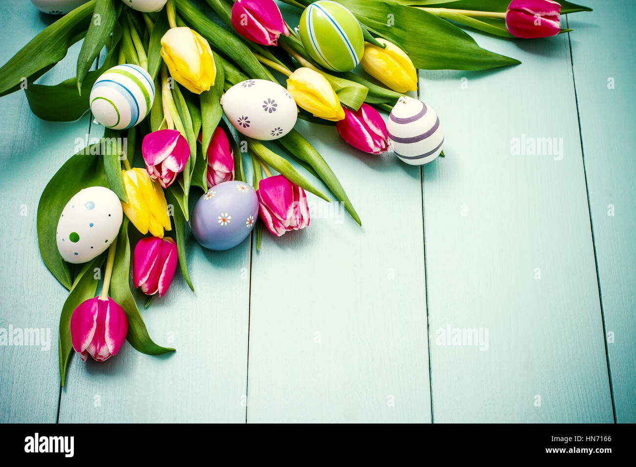 Red and yellow tulips with colorful Easter eggs, top view Stock Photo ...