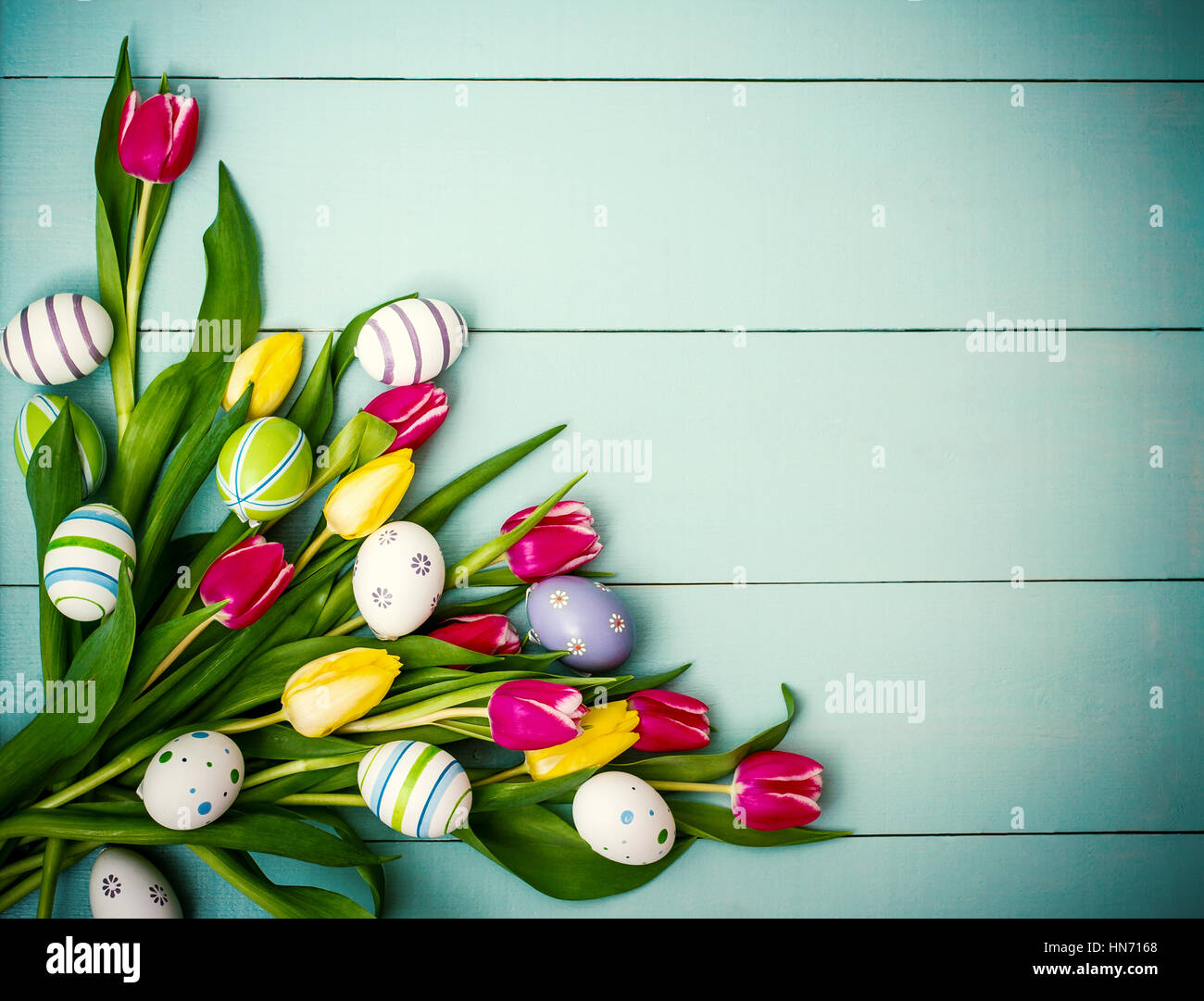 Red and yellow tulips with colorful Easter eggs, top view Stock Photo ...