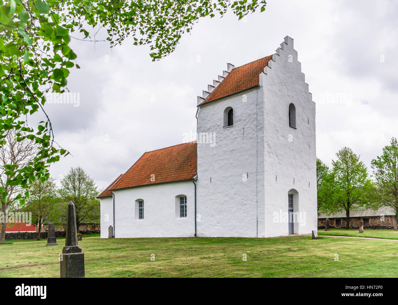 White rural church in the countryside, situated under some trees on a green lawn, Sjobo, Sweden - May 12, 2014 Stock Photo
