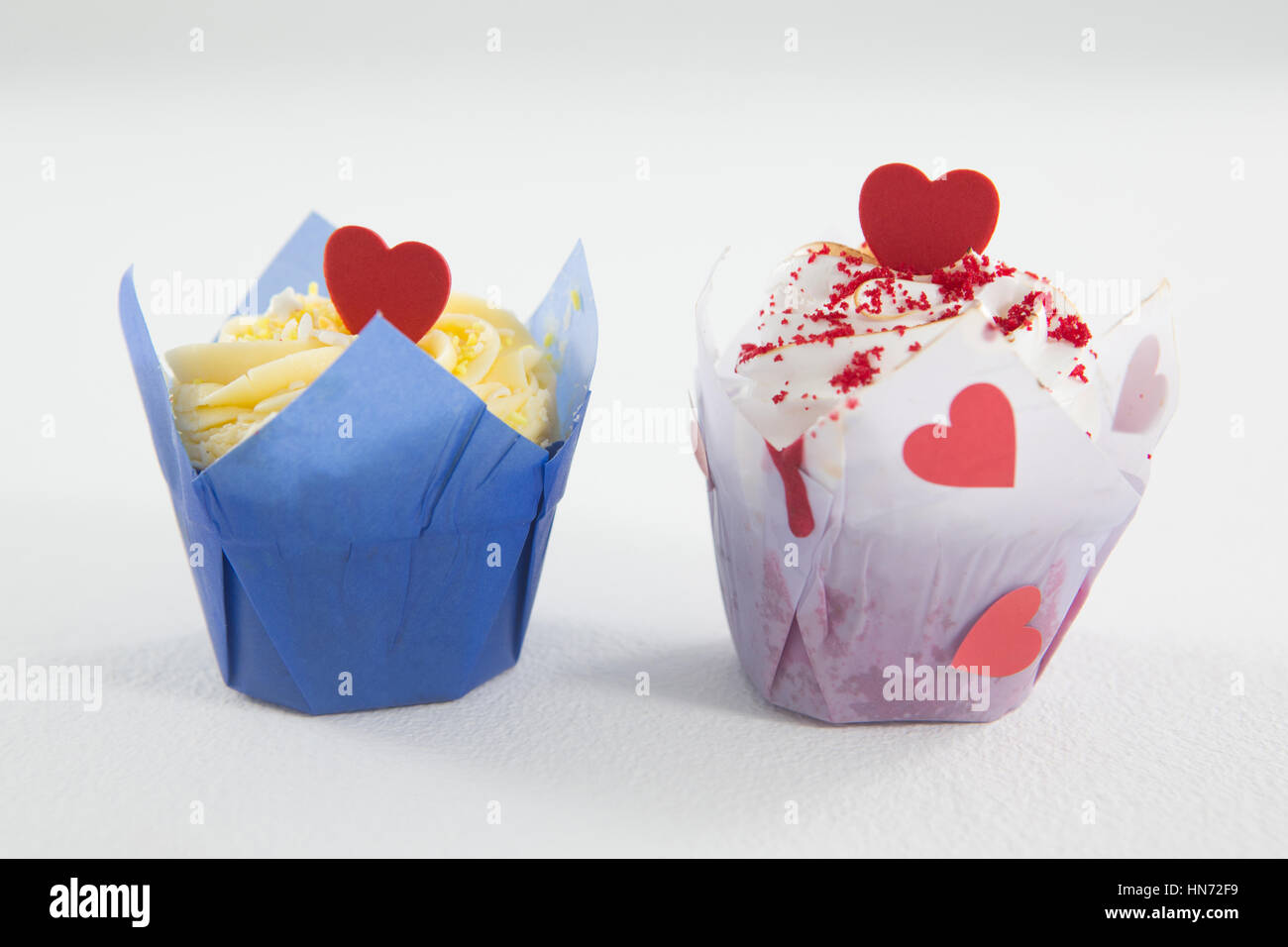 Close-up of delicious cakes with red heart shape on white background ...