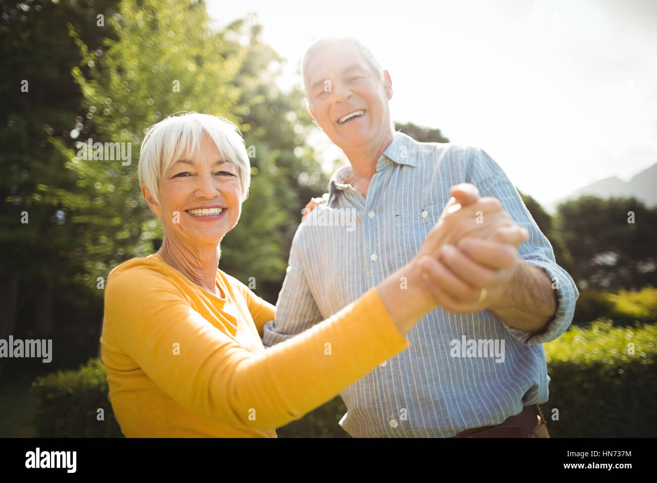 Portrait of happy senior couple dancing in park Stock Photo - Alamy