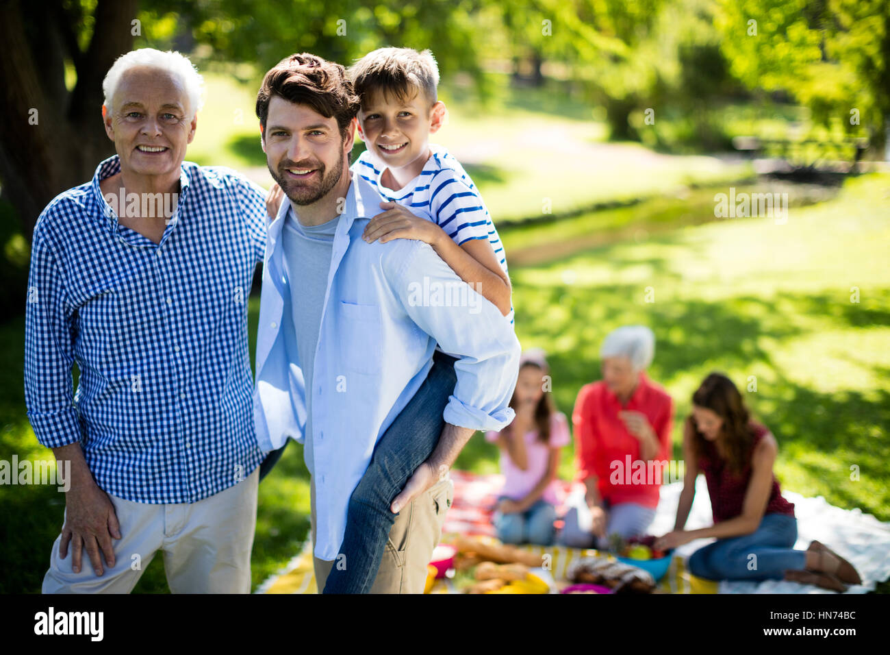 Portrait of happy family enjoying in park on sunny a day Stock Photo ...