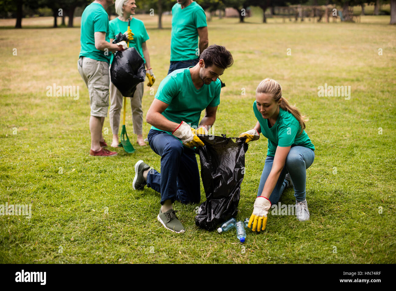 Team of volunteers picking up litter in park Stock Photo Alamy