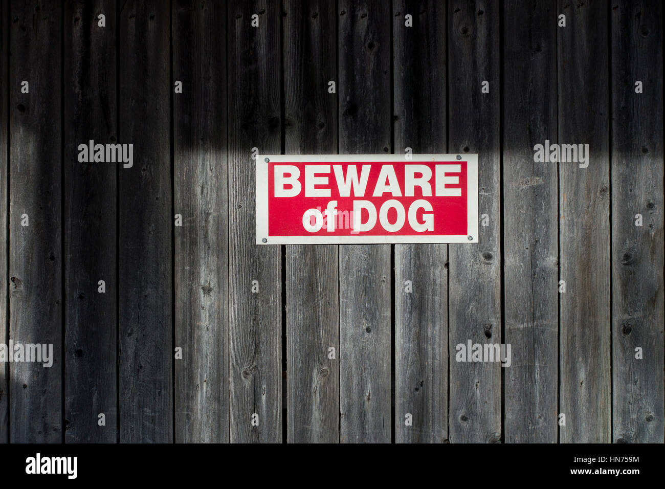 Beware of Dog sign posted on old wooden fence Stock Photo