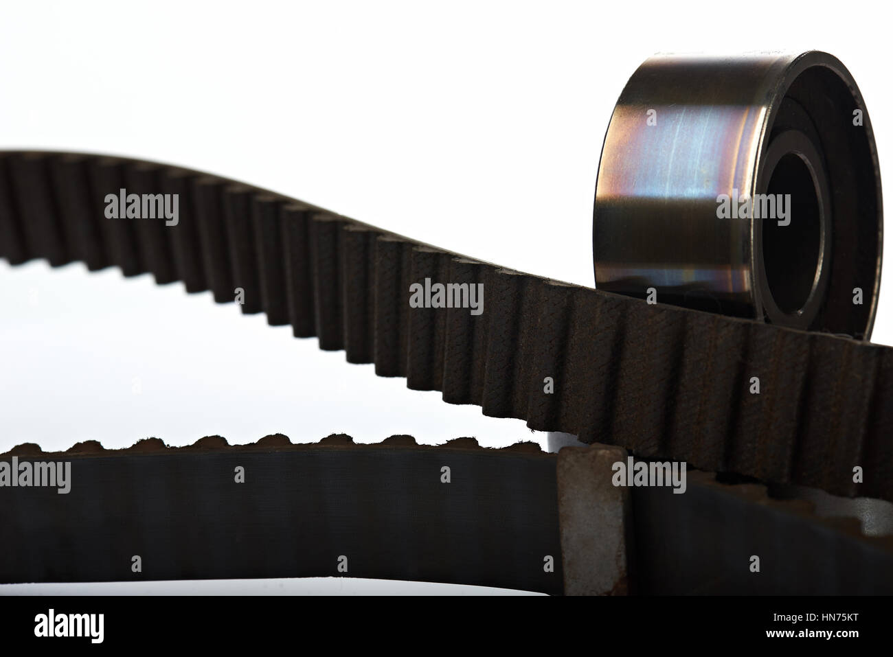 timing belt with used teeth and roller on white background Stock Photo