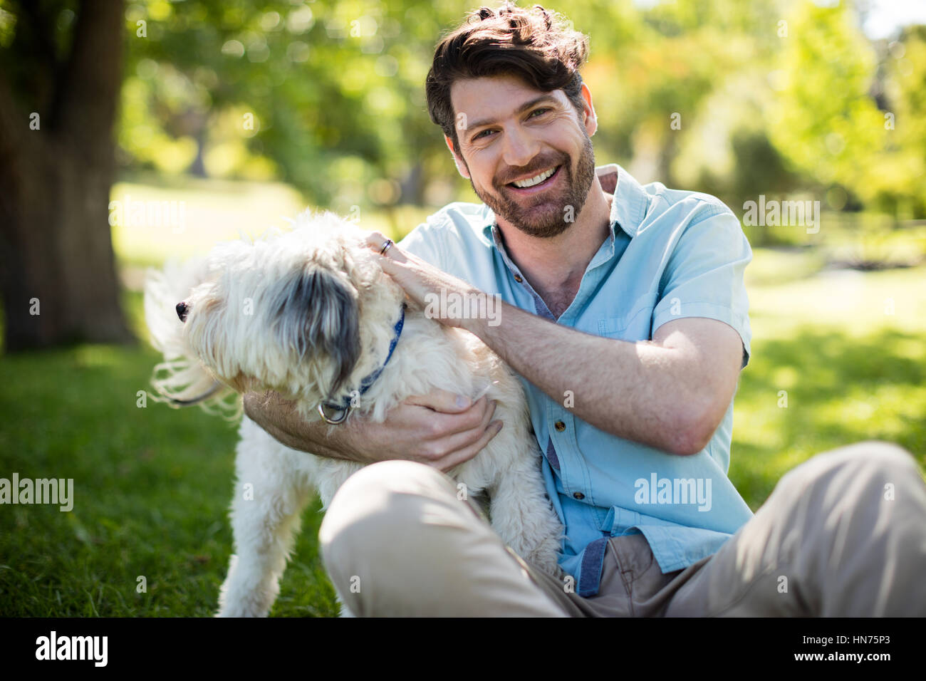 Portrait of man with dog in park on sunny a day Stock Photo - Alamy