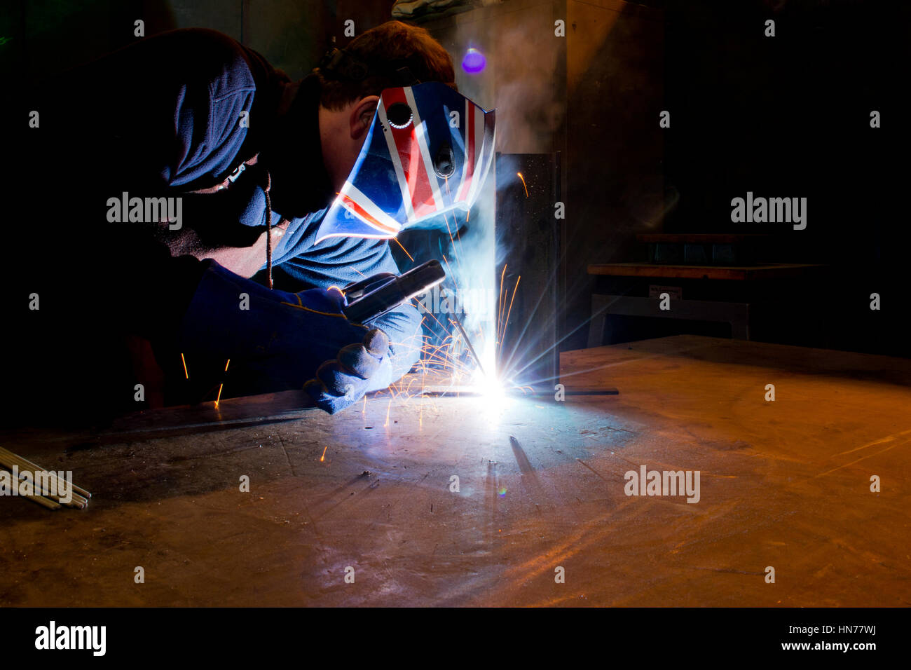 Welder Man mig process welding in protective workwear with safety mask Stock Photo