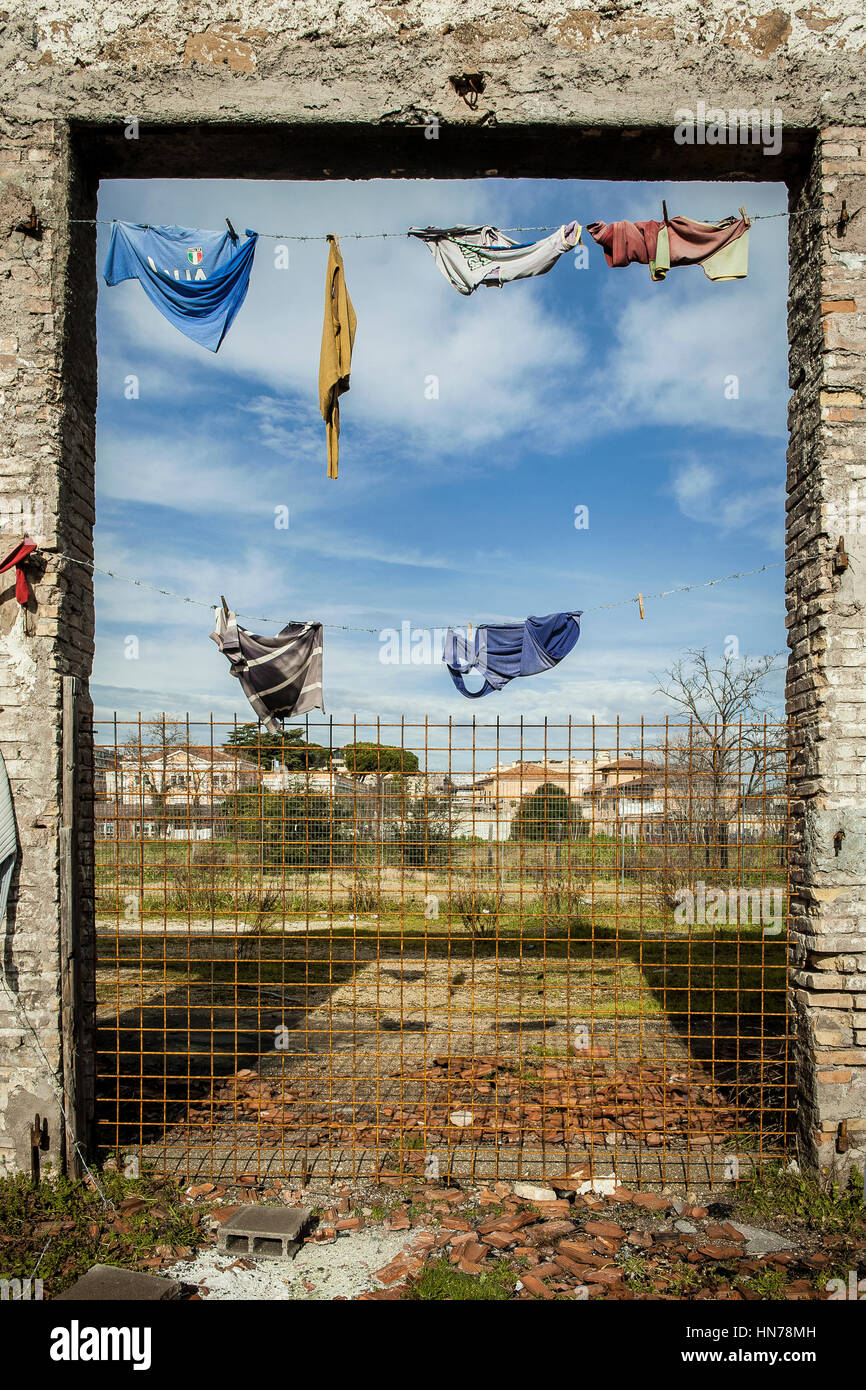 A sort of installation entitled 'Macedonia' on the south-west door entrance of the former factory Mira Lanza, with some clothes (those one remained) over hanging wires, like fruits on a tree. The latin title of the work of the French street artist seth is 'E fructu arbor cognoscitur' ('The tree can be recognized by its fruits') Stock Photo
