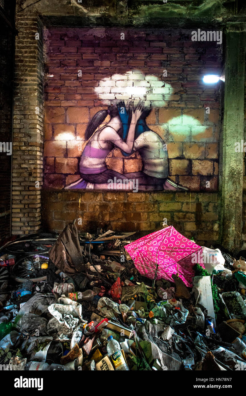 In the central hall of the former soap factory Mira Lanza, at the East wall, the French street artist Seth, painted a mural that shows a boy and a girl kissing. We suppose they are kissing because their faces are covered by hands and by a white cloud. The fact that the cloud in the wall has a lacking brick from which enters the light in the hall could means love is a way out from the horrible world shaped by adults. The title of the work is 'Omnia vincit amor' (Love conquers all) Stock Photo