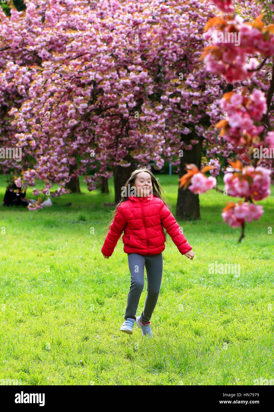 Happy beautiful girl in blossom park Stock Photo - Alamy