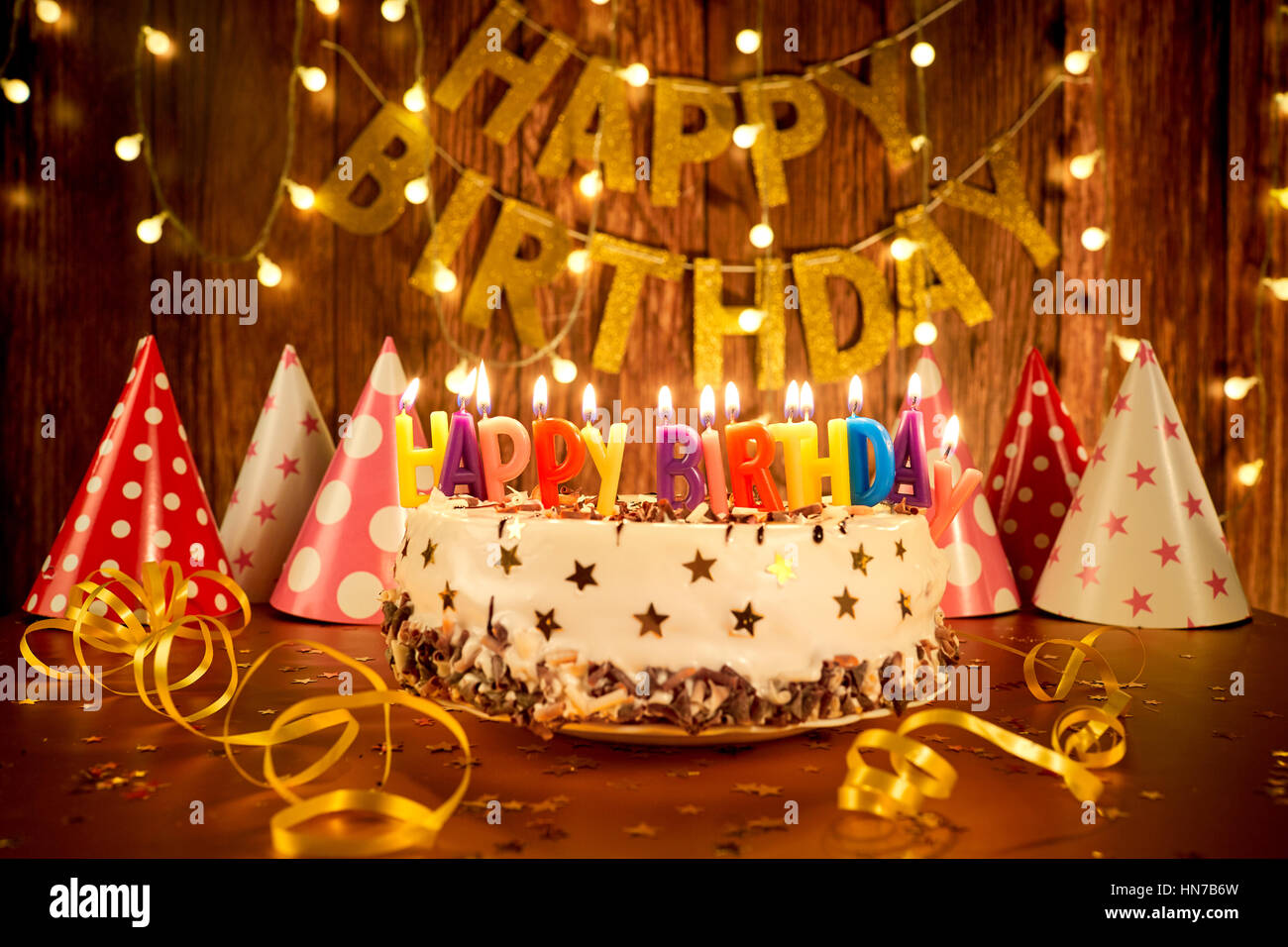 Happy birthday cake with candles on the background of garlands a ...
