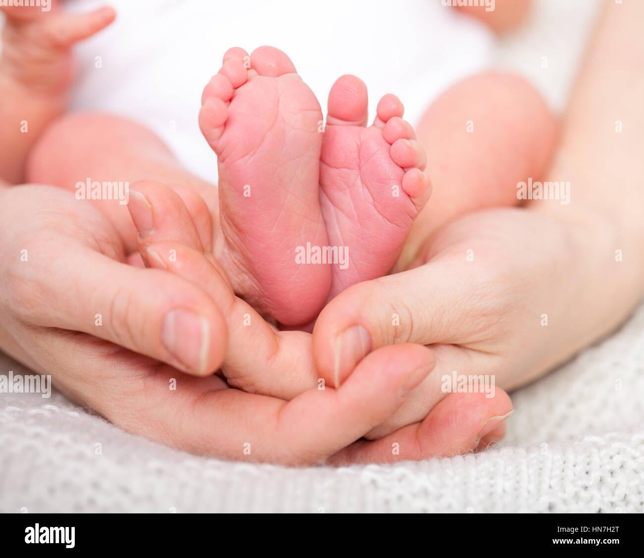 Mother holding her newborn baby's feet Stock Photo