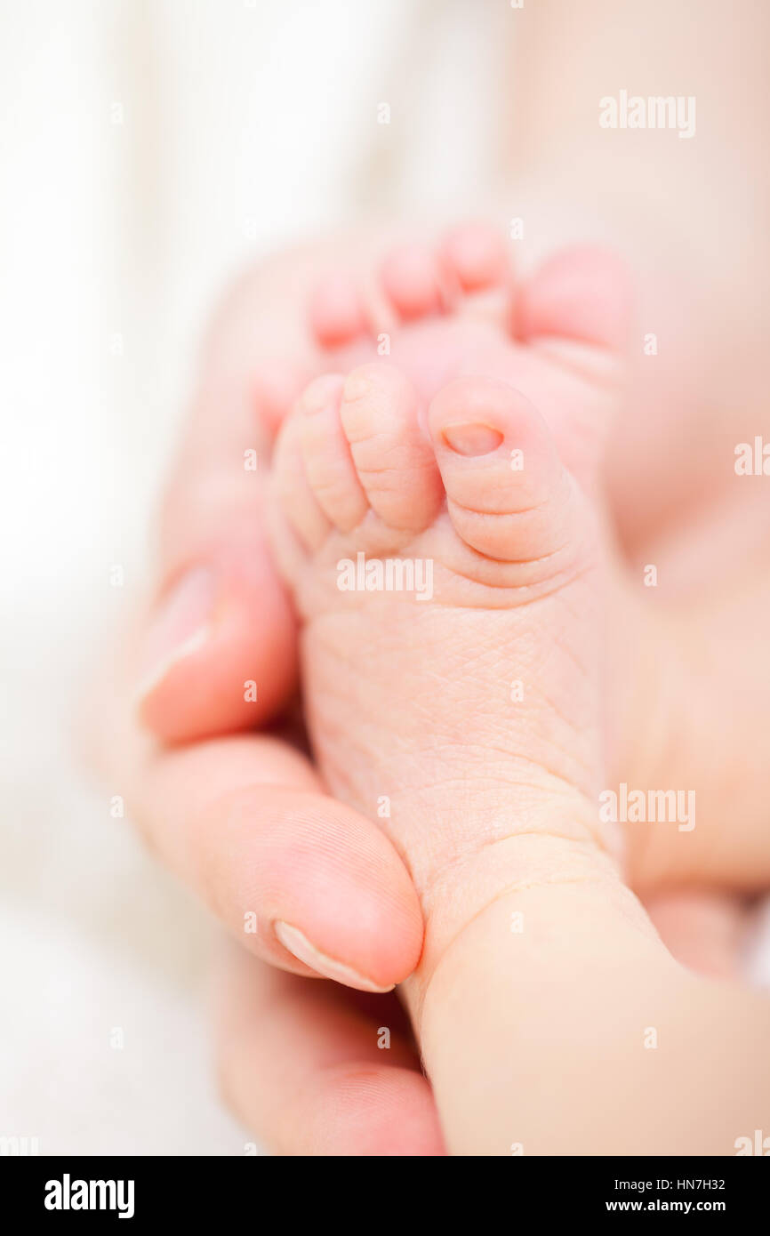 Mother holding her newborn baby's feet Stock Photo