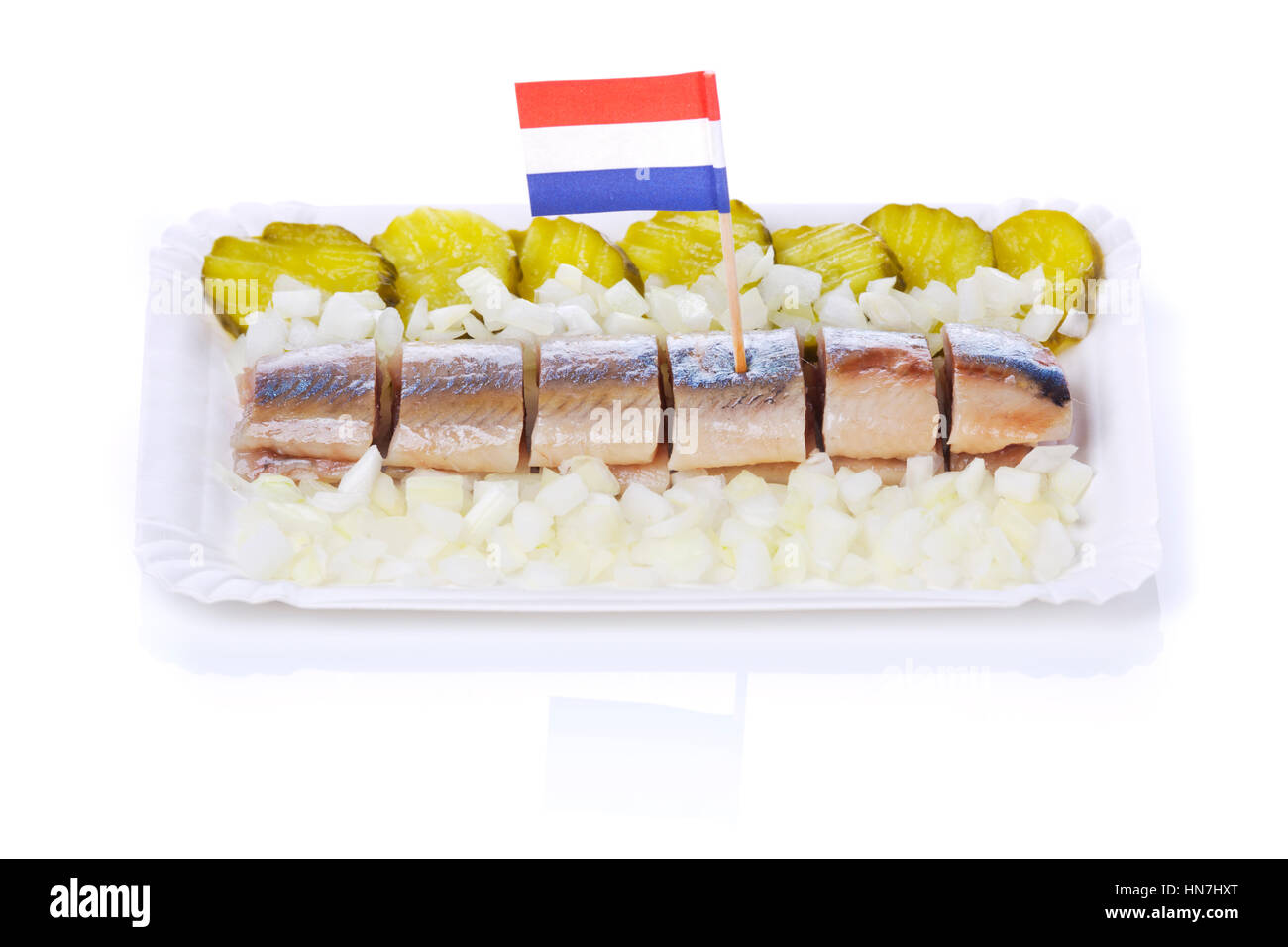 Dutch herring with gherkins and onions isolated on white. A traditional Dutch delicacy, with peak season at the end of spring when the first young her Stock Photo