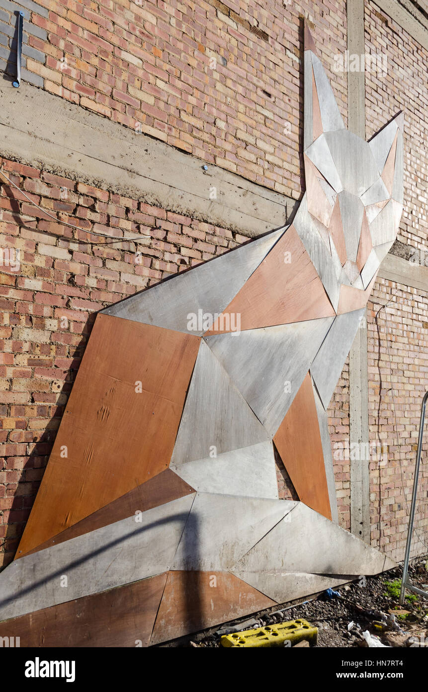 The Geo Fox wooden art by Anna Garforth mounted on a brick wall in Lower Essex Street, Birmingham Stock Photo