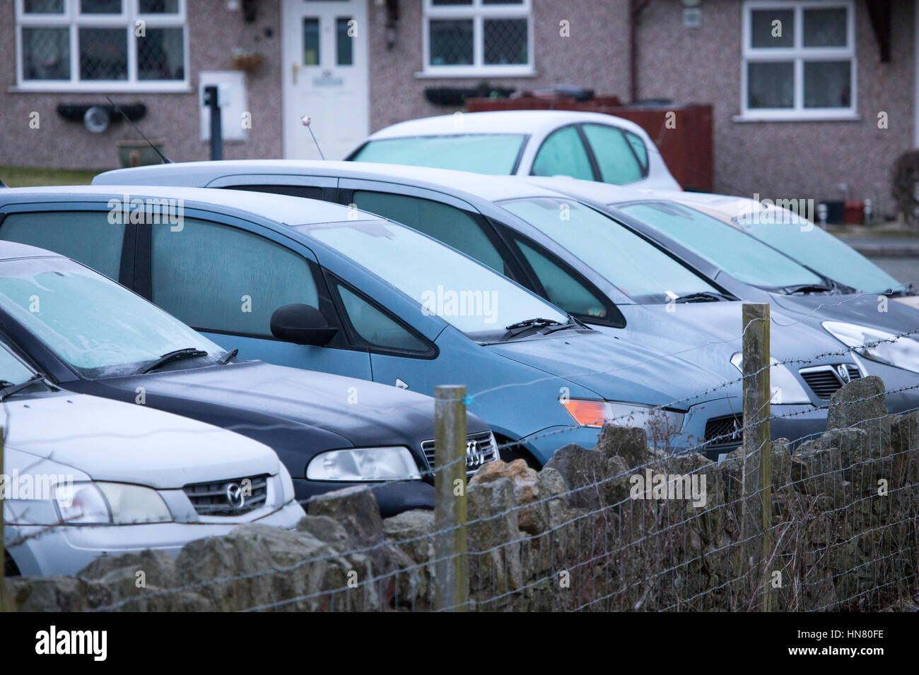 Frozen cars parked outside houses in the rural village of Halkyn in Flintshire during a cold overnight frost, Wales, UK Stock Photo