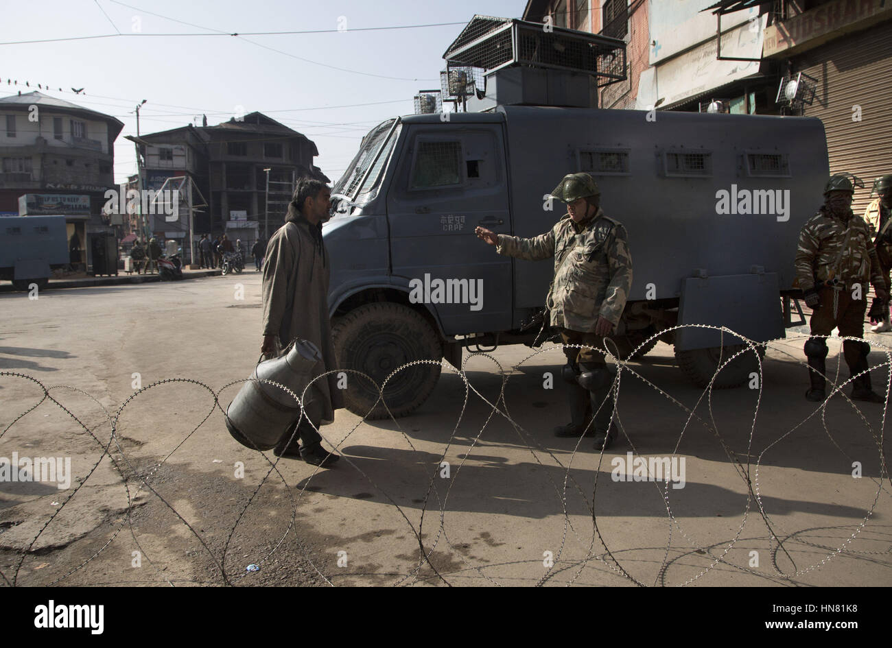 Srinagar, Kashmir. 9th Feb, 2017. An Indian paramilitary trooper stops a milkman near a barbed wire barricade during restrictions in Srinagar, summer capital of Kashmir, Feb. 9, 2017. Curfew-like restrictions have been imposed in several of Kashmir to prevent protests and clashes on the fourth death anniversary of Indian parliament-attack convict Mohammed Afzal Guru, officials said Thursday. Credit: Javed Dar/Xinhua/Alamy Live News Stock Photo