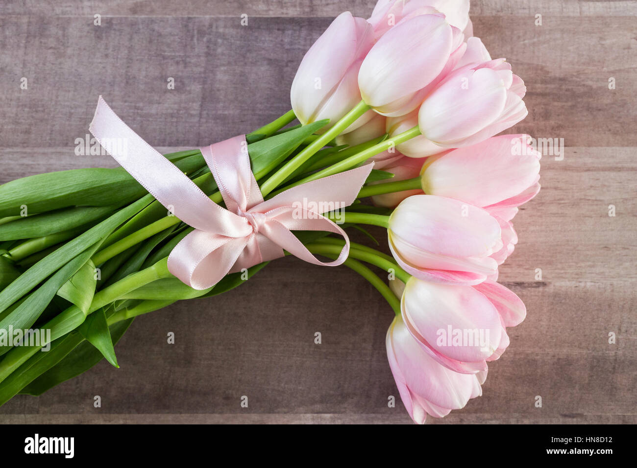 Bouquet of pink tulips on a wood background Stock Photo - Alamy