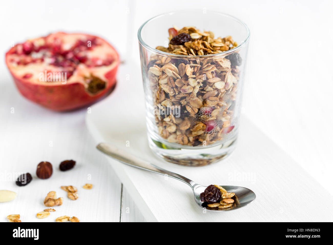 Fresh granola muesli in a glass with almonds, raisins and pomegranate. Healthy breakfast. Stock Photo