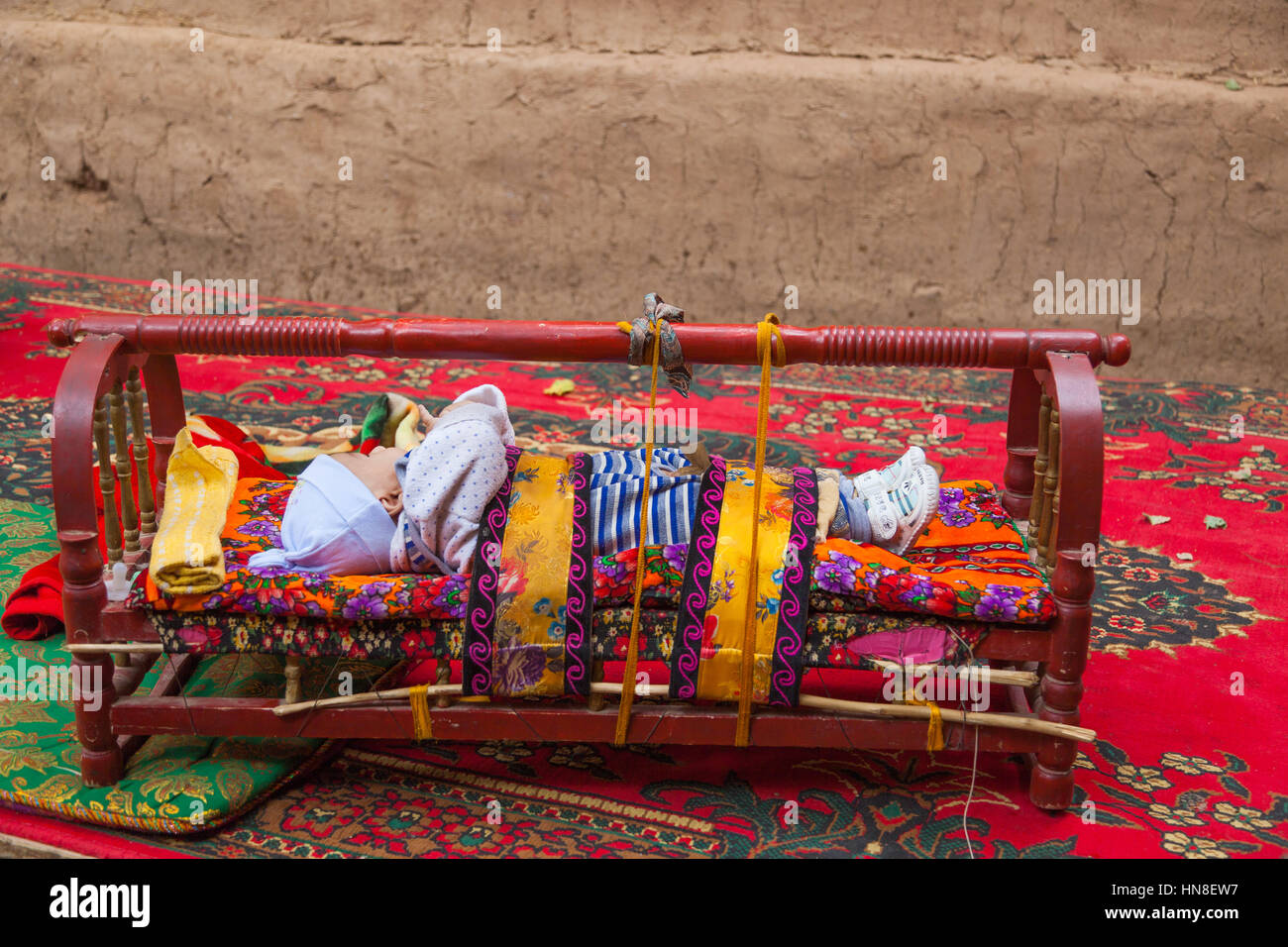 Baby sliping outdoors in wooden baby cots. Toyuq village, Xinjiang
