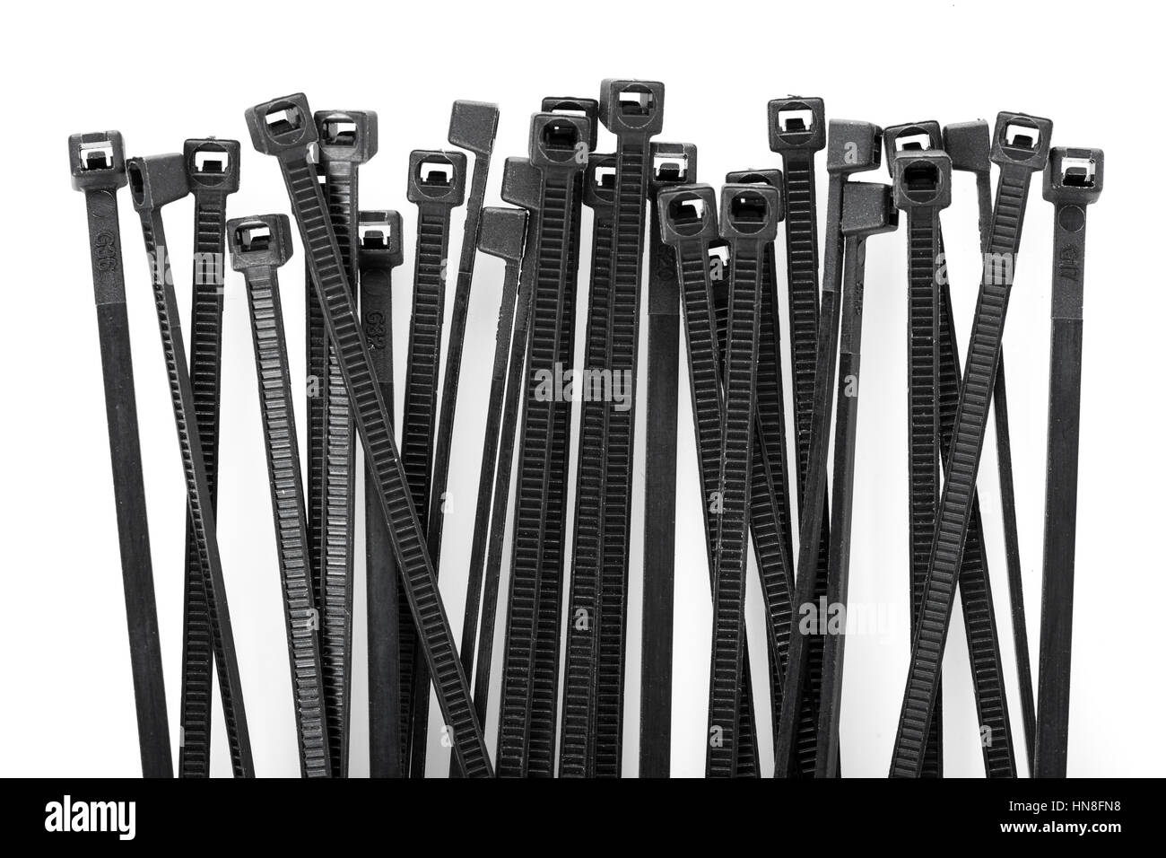 heap of black cable ties on white background Stock Photo Alamy