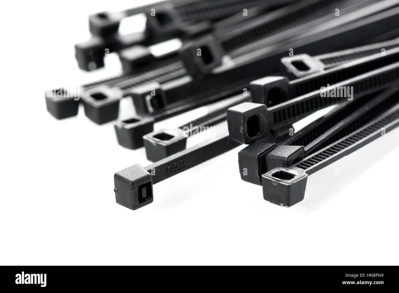 heap of black cable ties on white background Stock Photo Alamy